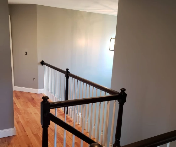 Interior Painting In Farmington 8 an empty room with a wooden floor and white railing.