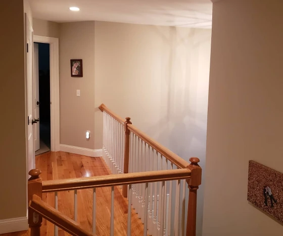 Interior Painting In Farmington 7 a hallway with a wood floor and white railing.