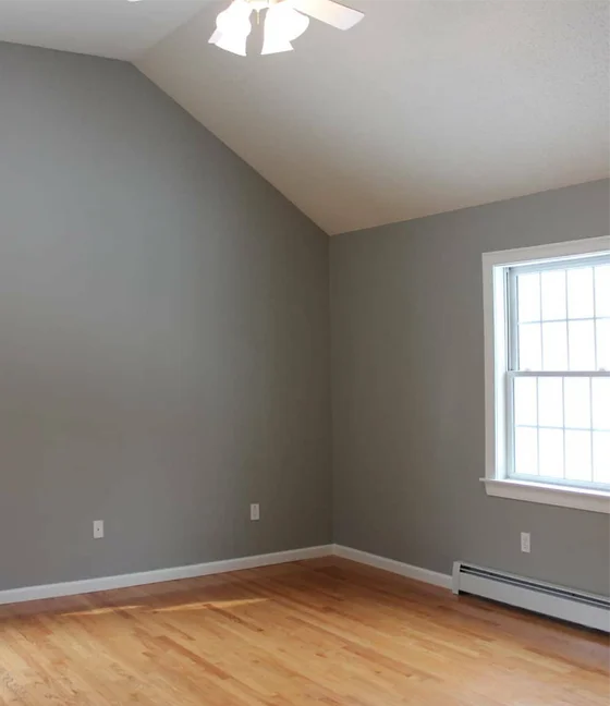 Interior Painting 5 an empty room with hard wood floors and a ceiling fan.