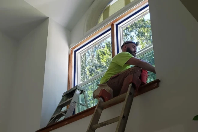 Why The Average Cost Of Interior Painting Varies By Location 2 Clean Cut Painting professional Tyler puts the finishing touches on a window trim