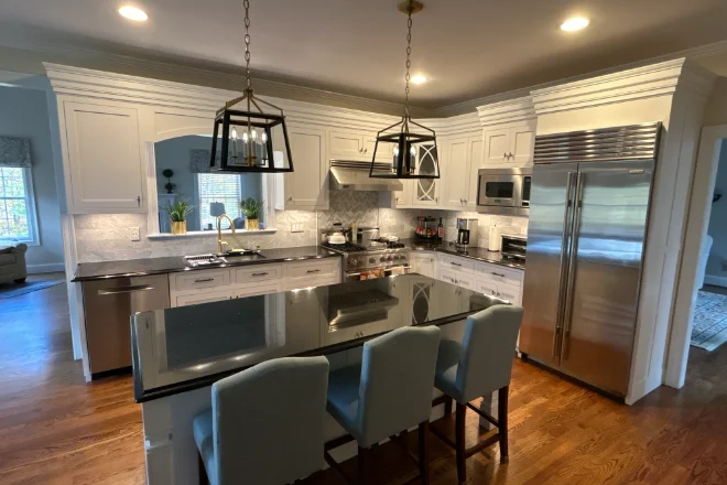 The Ultimate Guide to Kitchen Cabinet Painting in Marlborough, CT 1 A white kitchen with stainless steel appliances and hardwood floors.