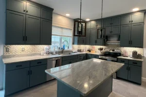 Blog 9 A kitchen with gray cabinets and marble counter tops.