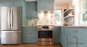 Blog 8 A kitchen with blue cabinets and a stainless steel stove.