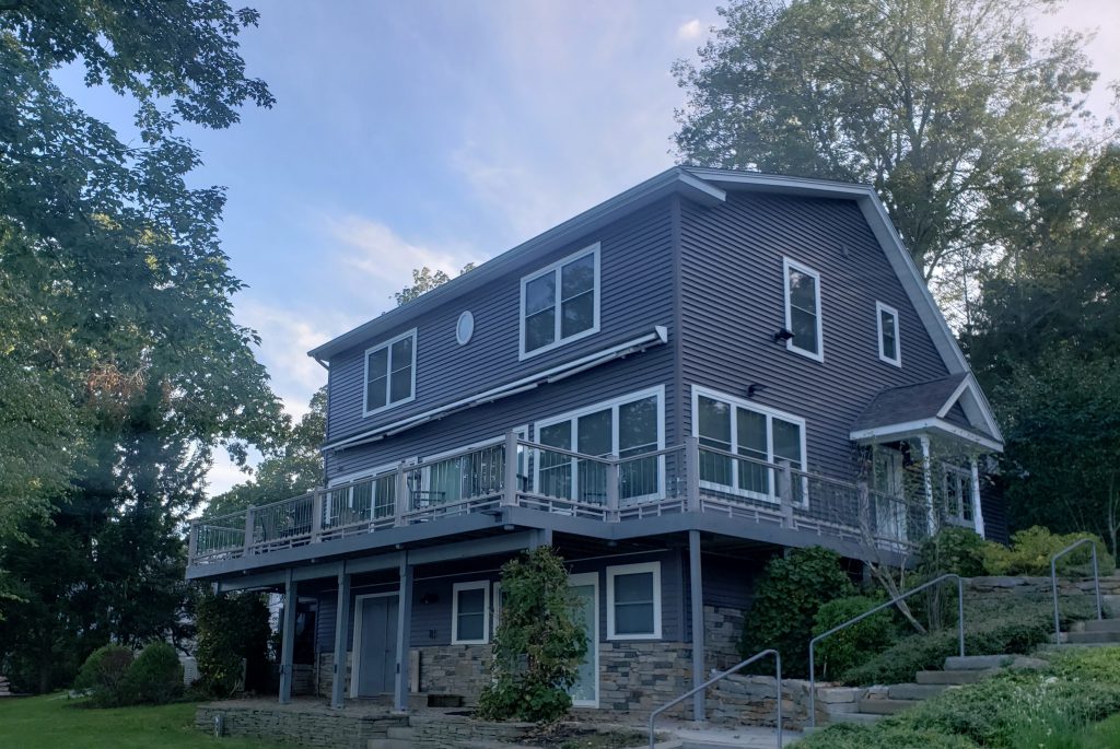Should You DIY or Hire a Professional Painter for Exterior House Painting? 1 A house with a deck and stairs on the side.